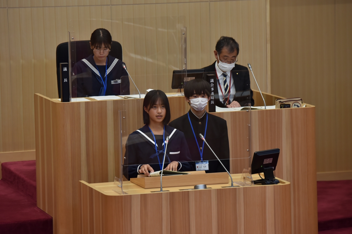 議長、議会事務局長を後方に、子ども議員の質問の様子の写真