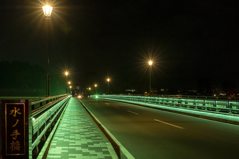 緑色に点灯する水の手橋を橋の上から撮影した写真