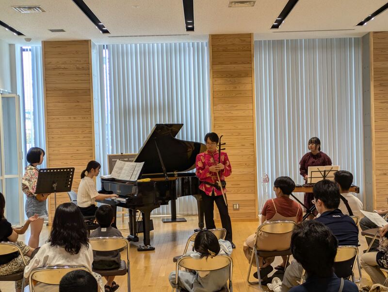 楽器を演奏しているところを眺める来場者